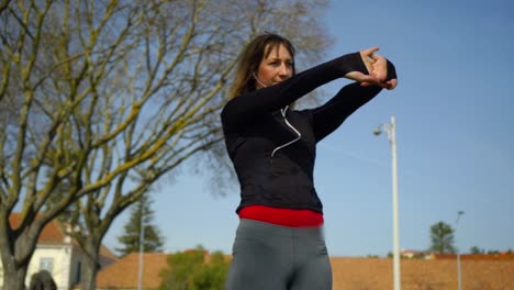 Beautiful-focused-sportswoman-exercising-in-park